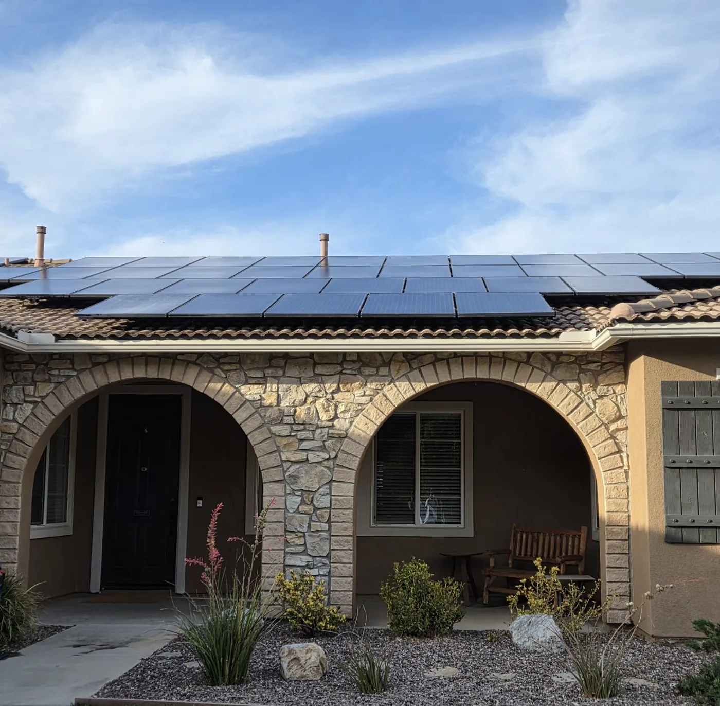 Clean solar panels viewed from the front of a one-story home